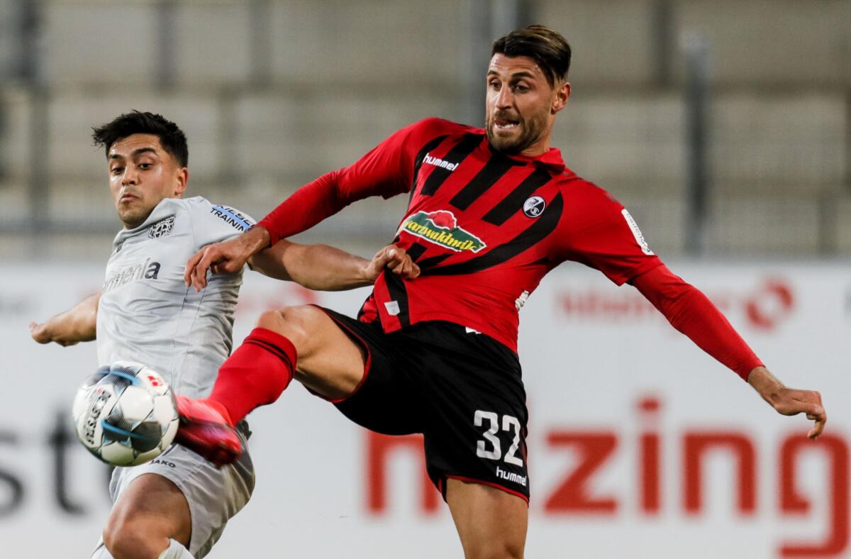 Bayern Leverkusen's Nadiem Amiri, left, tries to control the ball in front of Freiburg's Vincenzo Grifo on May 29.