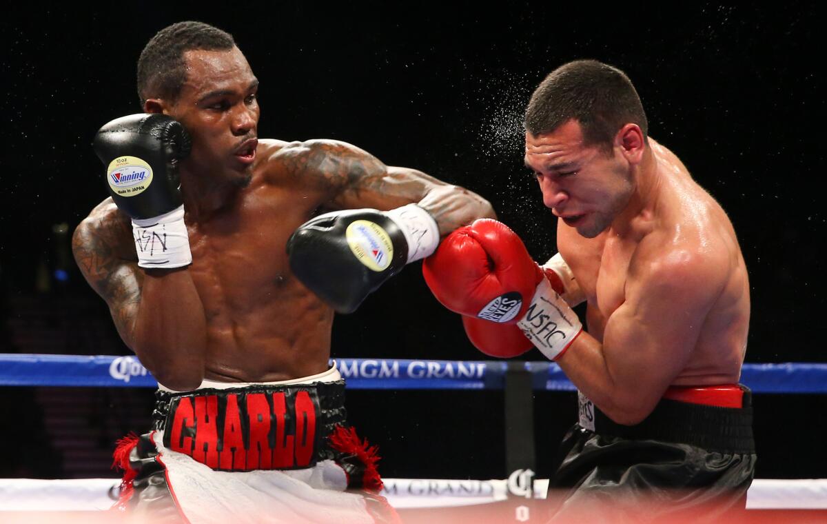 Jermell Charlo, left, trades punches with Mario Lozano during a bout on Dec. 13, 2014, in Las Vegas.