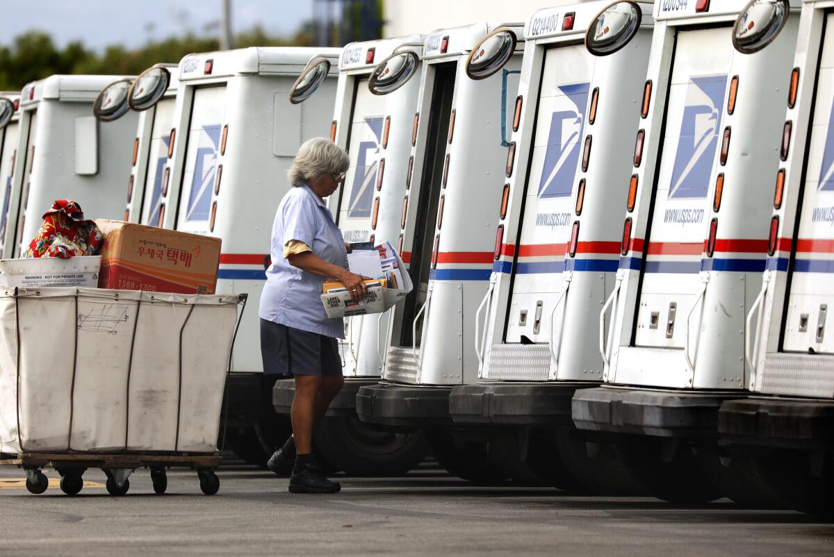 A mail carrier loads a truck for delivery at a U.S. post office in Torrance.