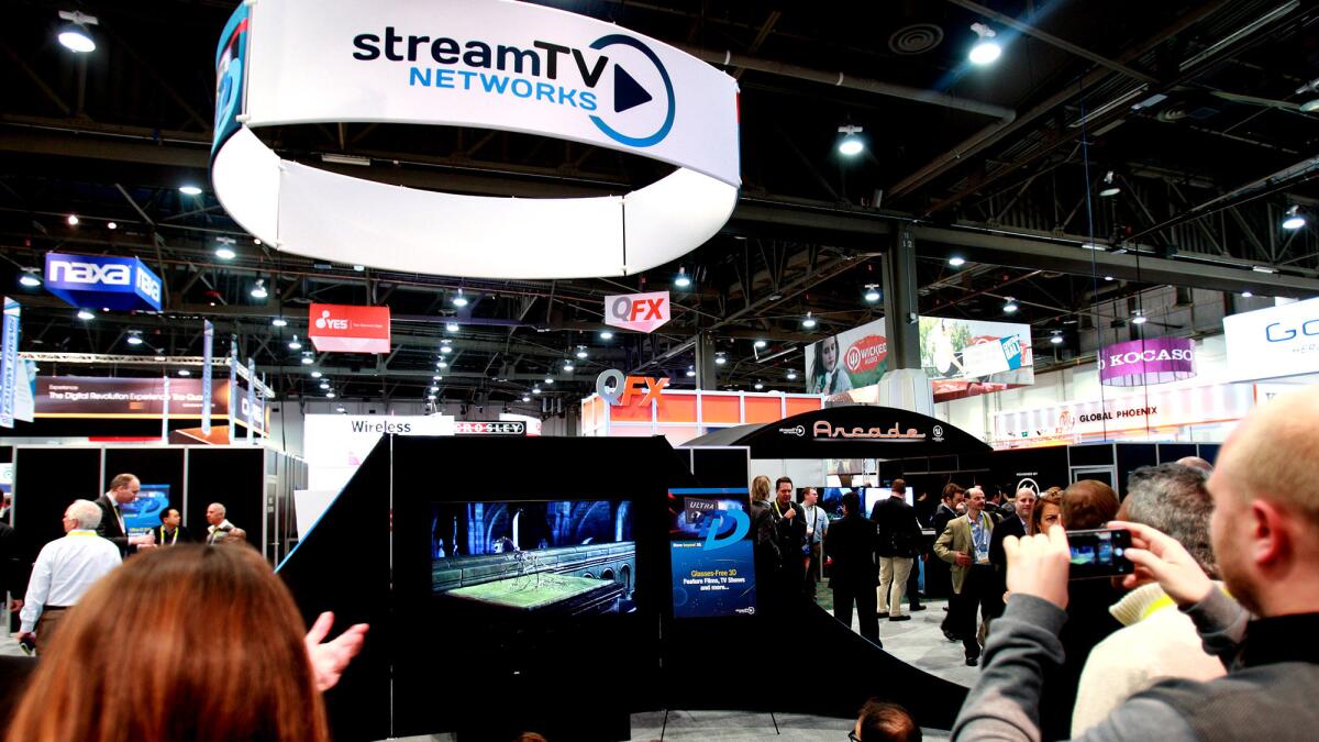 A crowd gathers to view streamTV Network's Ultra-D glasses-free 3D technology that is installed in ultra-HD TVs.