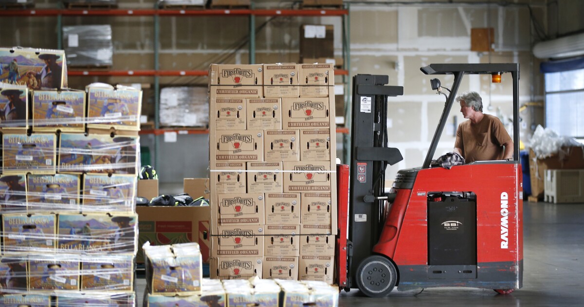 Bill McLeod moves some of the 5,880 pounds of fresh apples that was donated to Feeding San Diego on June 20, 2019