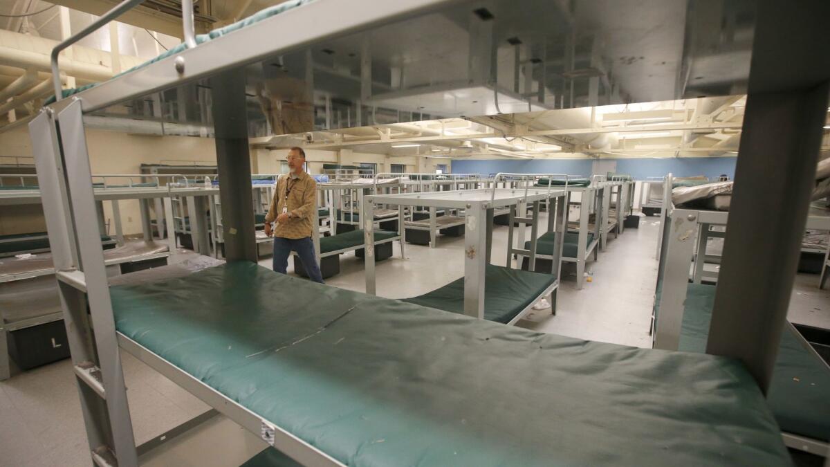 James Woolf, director of shelter operations at the Road Home, walks through a dorm.