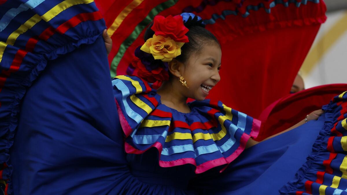 Sarahi Mendez, age 6, with 'Gary Ferrer & St John's Angels Folkloric' performs during Fiesta Broadway in downtown Los Angeles.