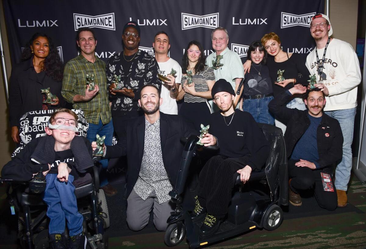 Filmmakers smile and pose with awards.