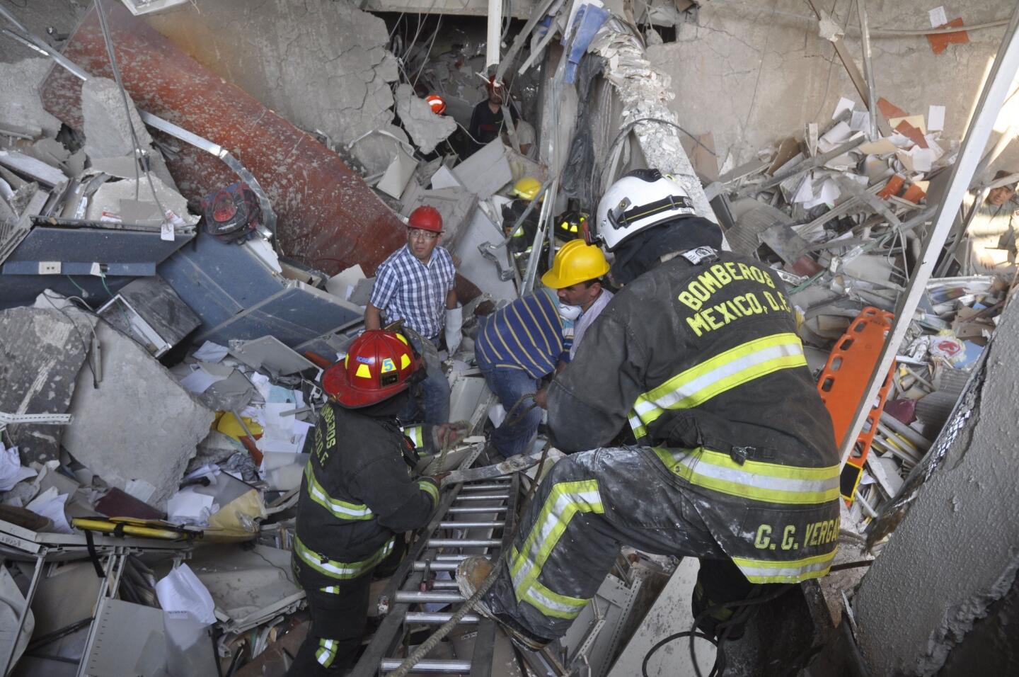 Firefighters and workers dig for survivors after an explosion next to the executive tower in the headquarters complex of Pemex, Mexico's state-owned oil company,in Mexico City.