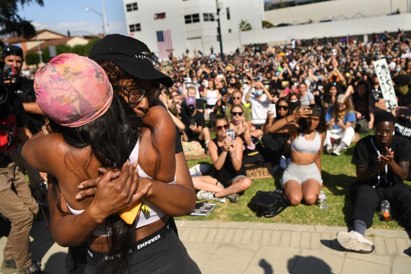 HOLLYWOOD, CALIFORNIA JUNE 6, 2020-A family member of Breonna Taylor, right, is hugged by another woman after speaking to protestors in beverly Hills Saturday. The protest was organzied by the Refuse Fascism group. (Wally Skalij/Los Angeles Times)