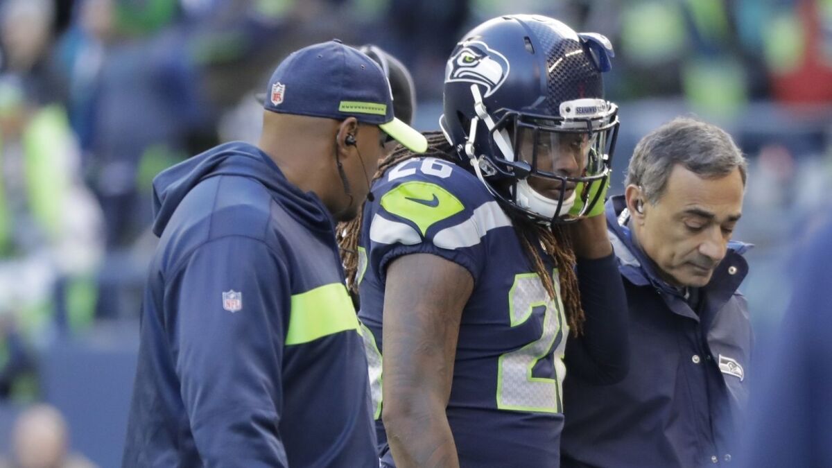 Seahawks cornerback Shaquill Griffin is helped off the field after sustaining an injury during the first half a game against the Arizona Cardinals on Dec. 30 in Seattle.