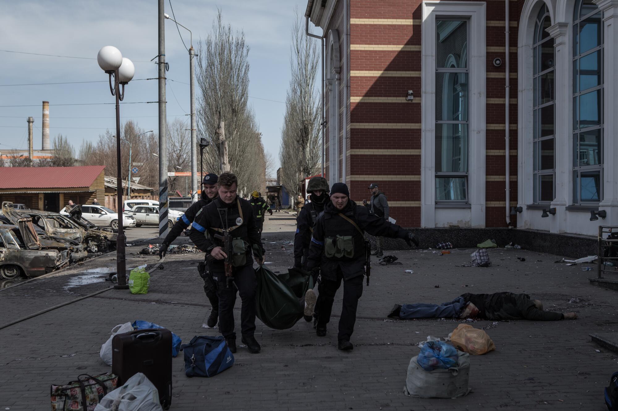 Security personnel move a body at the Kramatorsk train station.