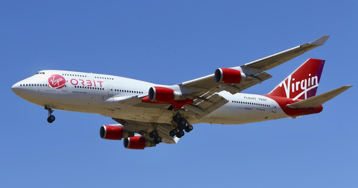 A white and red aircraft emblazoned with the Virgin Orbit logo.
