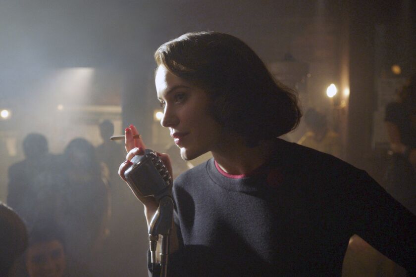 A woman leans toward a microphone in a smoky nightclub in 1960