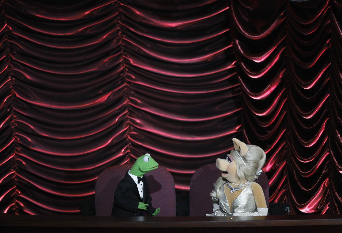 Miss Piggy, fashionable as always at the Academy Awards in 2012, will be wearing Vivienne Westwood in her new movie, "Muppets Most Wanted." What message will it send her beloved Kermie?