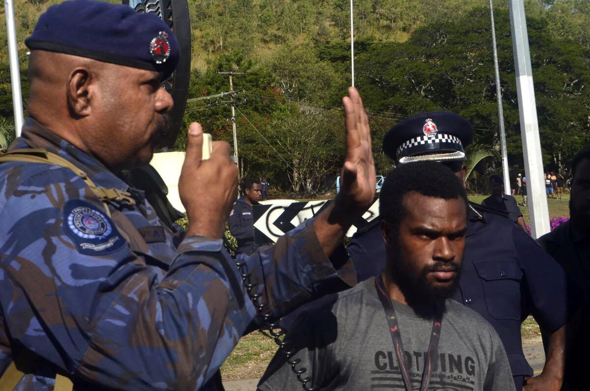 A police officer gestures while talking to students prior to their march from the University of the Papua New Guinea in Port Moresby on June 8.