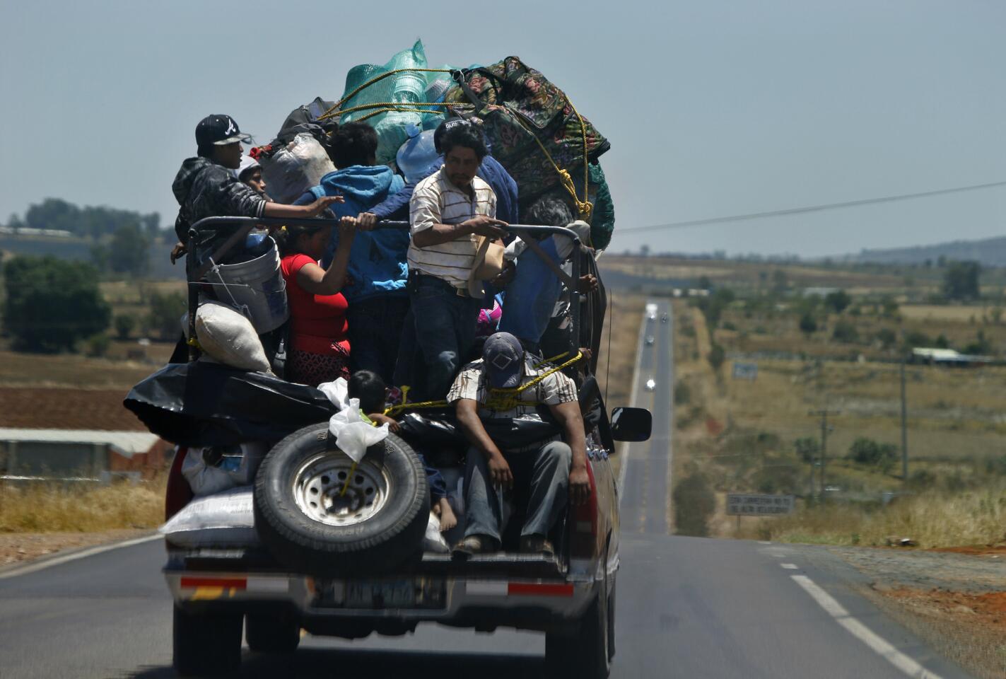 Alejandrina Castillo and her family travel from Sinaloa to a farm pueblo near Leon, Guanajuato. Those on the tailgate secure themselves with rope to avoid spilling out.