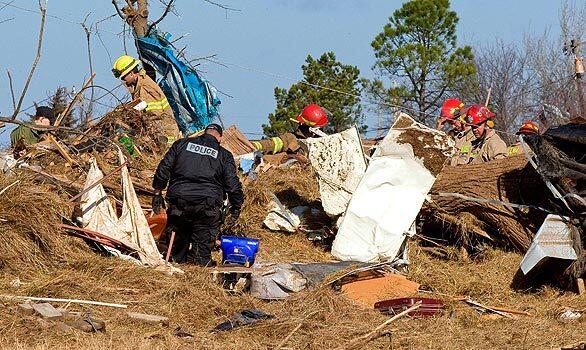 Police and fire crews comb through debris from homes in Lone Grove after a tornado hit the town in southern Oklahoma on Tuesday night, killing eight people.