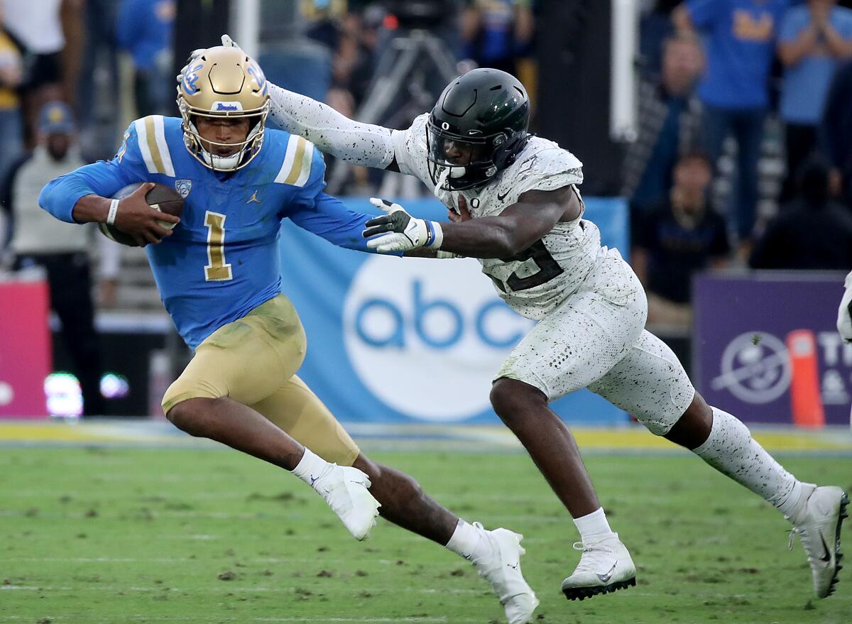UCLA quarterback Dorian Thompson-Robinson is brought down for a loss by Oregon safety Vernon McKinley III.