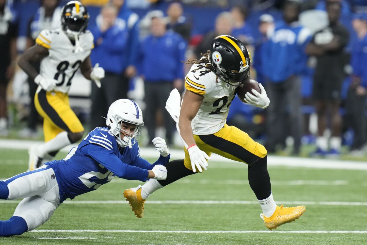 Benny Snell Jr. de los Steelers de Pittsburgh corre superando a Rodney Thomas II de los Colts de Indianápolis en el encuentro del lunes 28 de noviembre del 2022. (AP Foto/Michael Conroy)