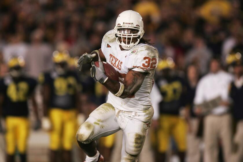 PASADENA, CA - JANUARY 01: Runningback Cedric Benson #32 of the Texas Longhorns runs with the ball against the Michigan Wolverines in the 91st Rose Bowl Game at the Rose Bowl on January 1, 2005 in Pasadena, California. (Photo by Jed Jacobsohn/Getty Images)