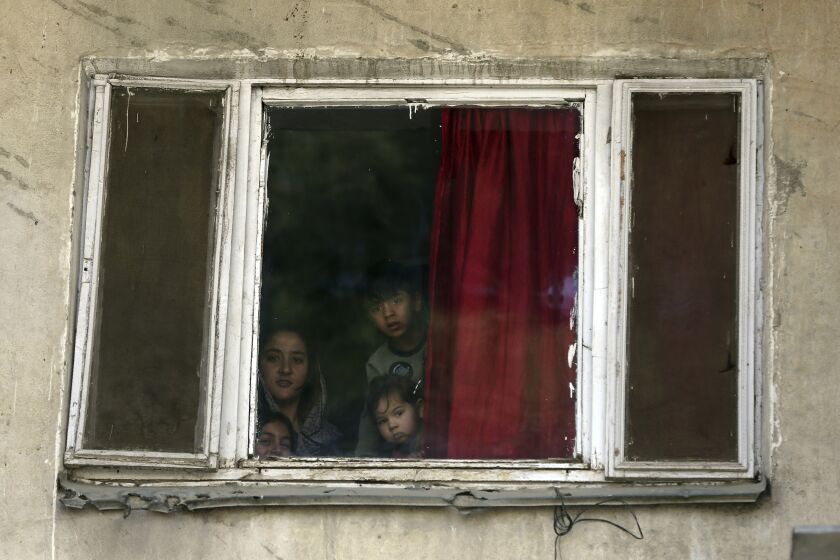 Children look out from the window of their house during a lockdown to help curb the spread of the new coronavirus in Kabul, Afghanistan, Tuesday, April 7, 2020. (AP Photo/Rahmat Gul)