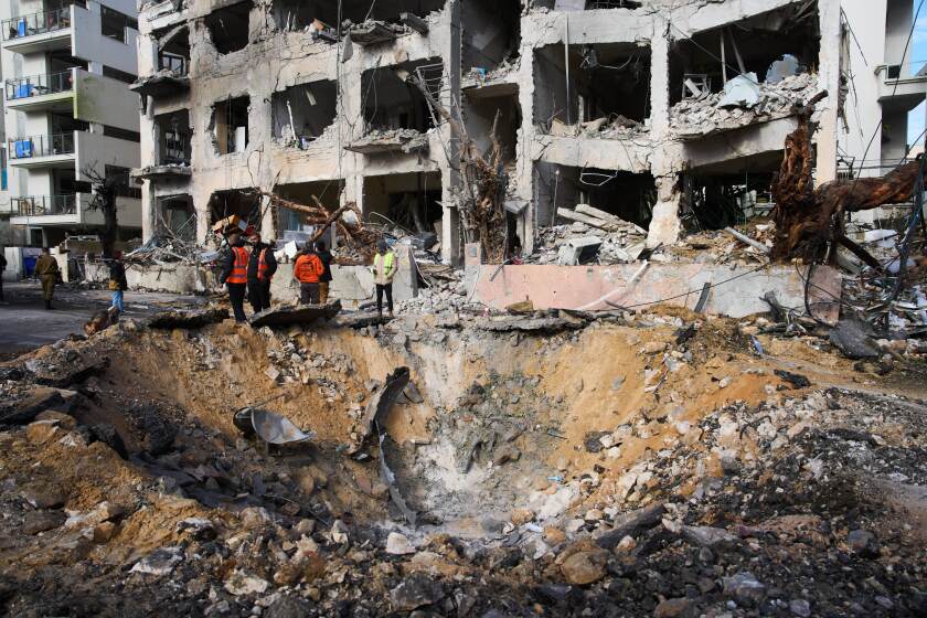 Trabajadores de rescate y personal militar observan el lugar donde impactó un misil iraní en Tel Aviv, Israel, el domingo 1 de marzo de 2026. (AP Foto/Oded Balilty)