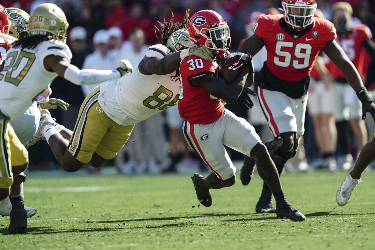 Georgia running back Daijun Edwards (30) is brought down from behind by Georgia Tech defensive lineman Zeek Biggers (88) during the first half of an NCAA college football game Saturday, Nov. 26, 2022 in Athens, Ga. (AP Photo/John Bazemore)