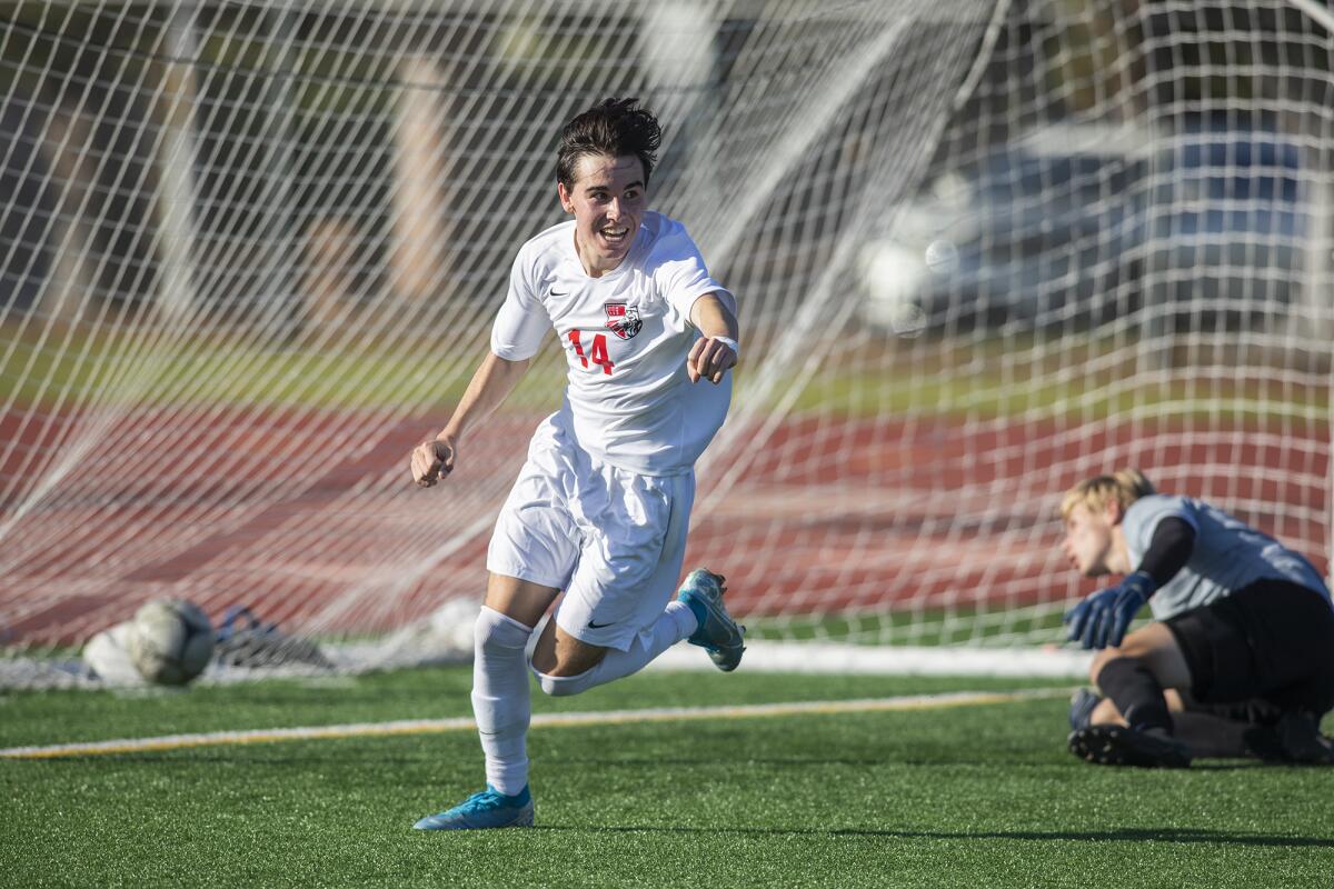 Mater Dei's Patrick Neill celebrates a goal as Fountain Valley goalkeeper Connor Trapp looks on from the ground in the first round of the CIF Southern Section Division 1 playoffs on Wednesday.