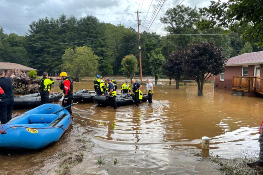 In this image provided by New Hanover County Fire Rescue, members of North Carolina’s Task Force 11, based in New Hanover County, are shown during rescue efforts in Canton, N.C, on Tuesday, Aug. 17, 2021. Authorities said that dozens of water rescues were performed after the remnants of Tropical Storm Fred dumped rain on the mountains of North Carolina. (New Hanover County Fire Rescue via AP)