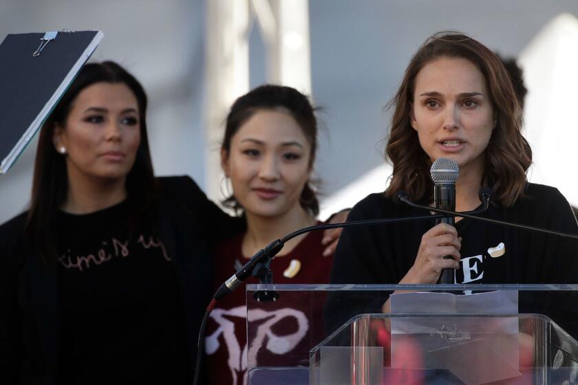 Actress Natalie Portman, right, speaks as she is joined by Eva Longoria, background left, and Constance Wu at a Women's March against sexual violence and the policies of the Trump administration Saturday, Jan. 20, 2018, in Los Angeles. (AP Photo/Jae C. Hong)