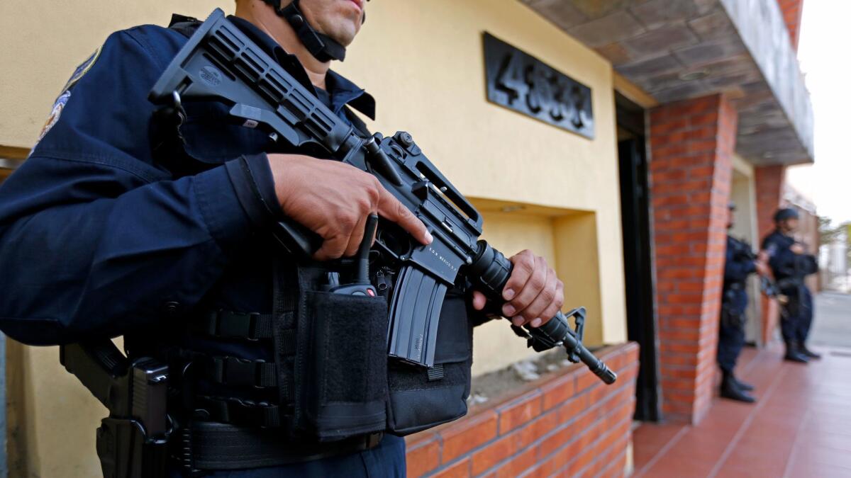 Police stand guard outside Semanario Zeta, a weekly investigative publication, in Tijuana in April 2017. Businesses and institutions have beefed up security because of the rising homicide rate in Mexico.