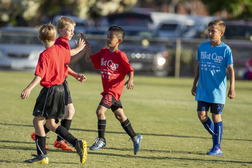 Costa Mesa Kaiser Elementary's Dereck Torres, right, gets high-fives from his teammates after scoring a goal against Corona del Mar Harbor View in a Daily Pilot Cup boys' third- and fourth-grade Silver Division pool-play match at Jack R. Hammett Sports Complex in Costa Mesa on Tuesday.
