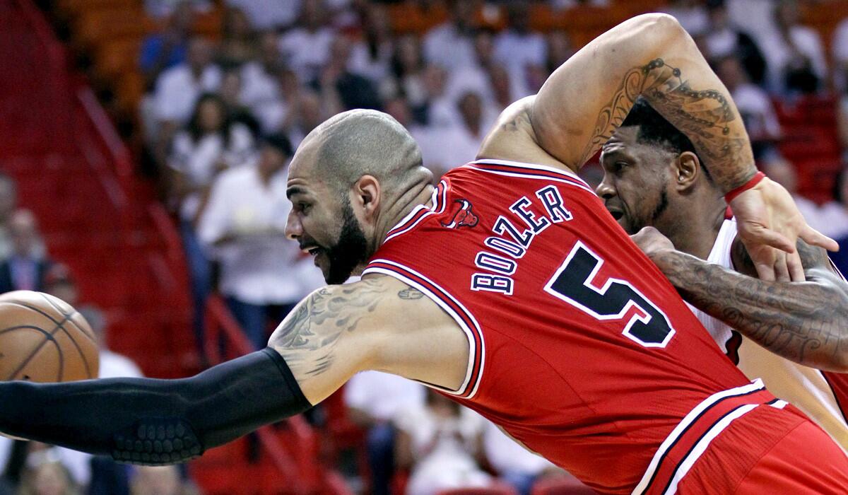 Bulls power forward Carlos Boozer stretches for the ball during a May playoff game against Udonis Haslem and the Heat.