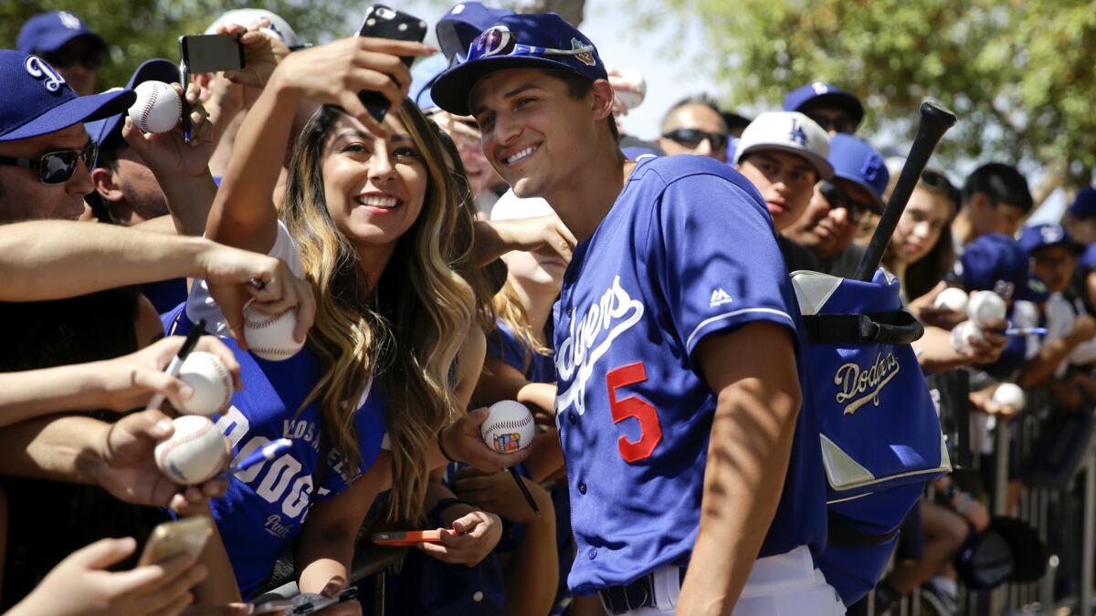 Dodgers shortstop Corey Seager pauses for a photo with a fan before a spring training game on March 21.