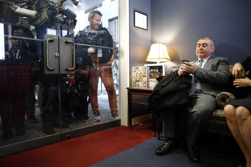 FILE - This photo from Wednesday Jan. 29, 2020, shows Lev Parnas, right, looking through his phone as he waits in the office of Senate Minority Leader Sen. Chuck Schumer of N.Y. A judge on Wednesday, July 14, 2021 rejected a selective prosecution claim by a one-time associate of Rudy Giuliani who faces an October trial with two others on charges that they made illegal campaign contributions. (AP Photo/Patrick Semansky, File)
