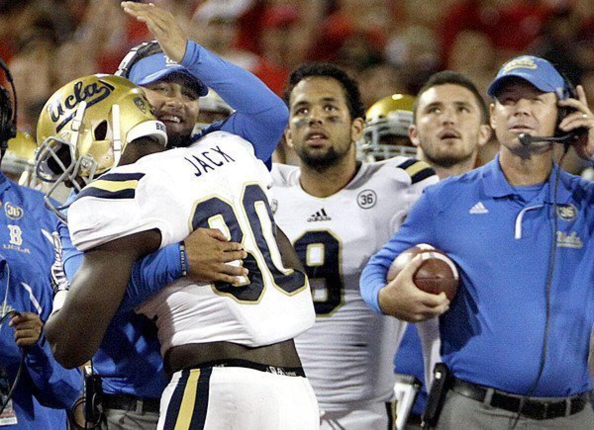 Linebacker Myles Jack, left, is congratulated by his UCLA teammates after recovering the ball in the end zone during the second half of the Bruins' 31-26 win over the Arizona Wildcats on Saturday in Tucson, Ariz.