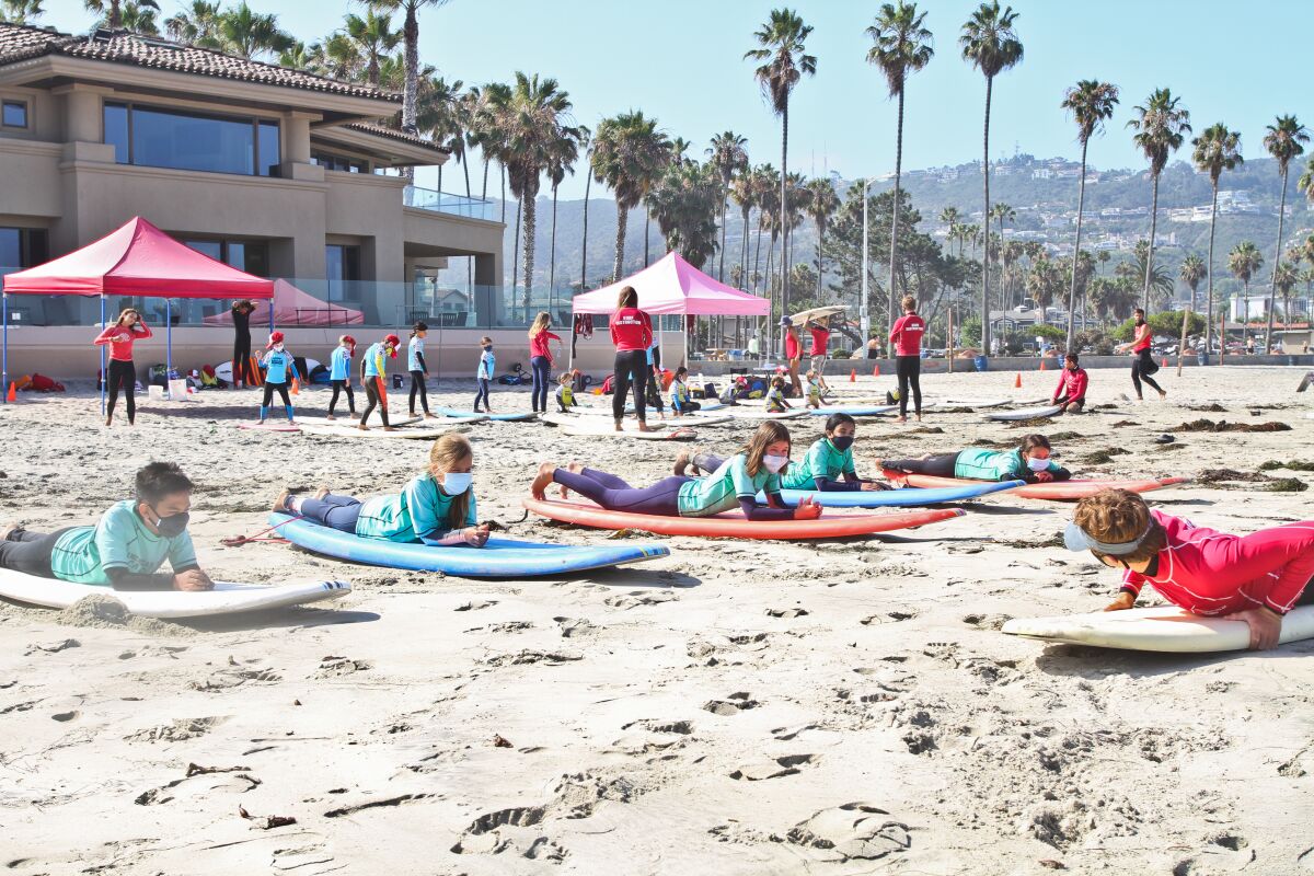 Students at Surf Diva's surf school in La Jolla must wear masks while on land.