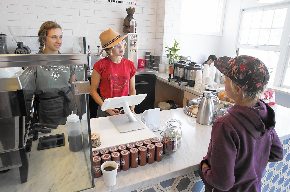 Bonnie Jean Worlend, left, and Shelby Harvey help a young surfer with his favorite item at the Bear Coast Coffee shop.