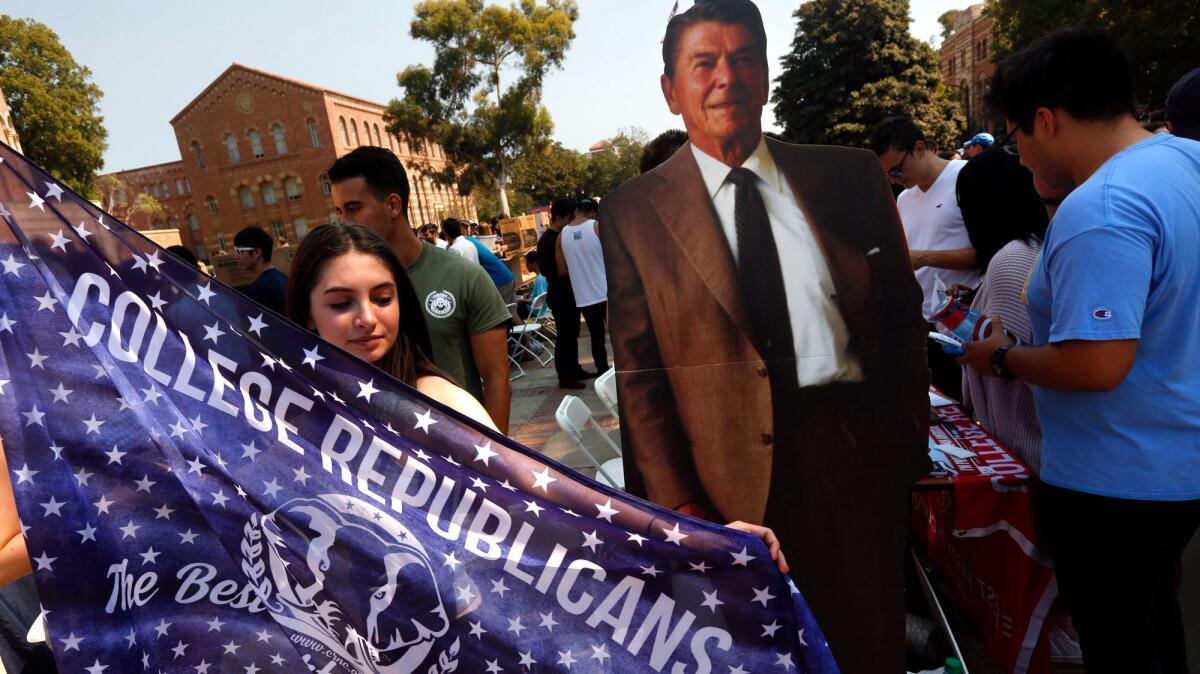 UCLA senior Emma Bock, 20, stands next to a cardboard figure of President Reagan as she and other Bruin Republicans recruit members at UCLA's annual student involvement fair.