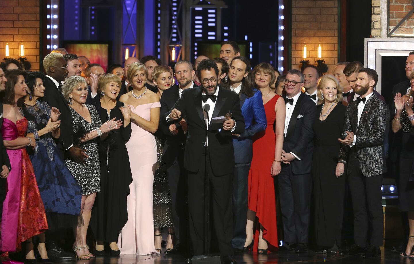 Playwright Tony Kushner, center, and the cast and crew of "Angels in America" accept the award for best revival of a play at the 72nd Tony Awards.