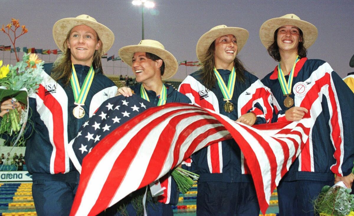 FILE - The American 4x100 women's medley relay team celebrate on the pool deck after they won the gold medal at the World Swimming Championships in Perth, Australia, Friday, Jan. 16, 1998. From left, Jenny Thompson, Lea Maurer, Amy Van Dyken and Kristy Kowal. Two-time Olympic medalist Maurer was named head coach of Southern California’s men’s and women’s swimming teams Friday, April 1, 2022, making her the first woman to lead both programs. (AP Photo/Steve Holland, File)