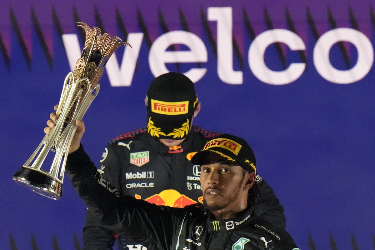 Mercedes driver Lewis Hamilton of Britain celebrates winning the Formula One Saudi Arabian Grand Prix in front of the second placed Red Bull driver Max Verstappen of the Netherlands, in Jiddah, Sunday, Dec. 5, 2021. (AP Photo/Hassan Ammar)
