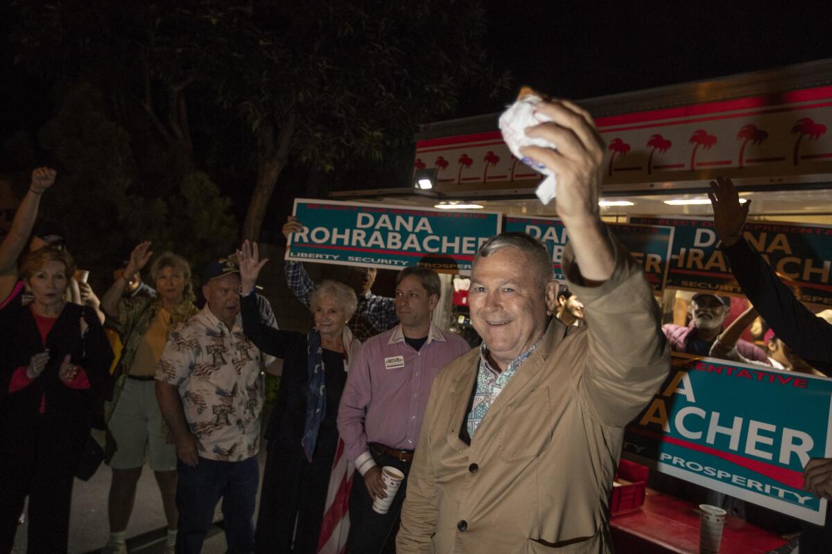 Rep. Dana Rohrabacher holds up an In-N-Out Burger as he thanks supporters at his headquarters in Costa Mesa.