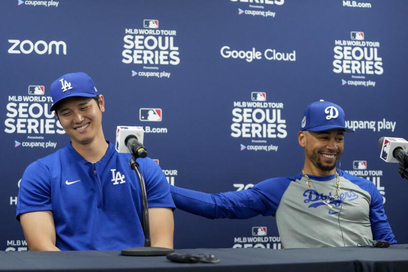 Los Angeles Dodgers' Shohei Ohtani, left, and Mookie Betts react during a news conference.