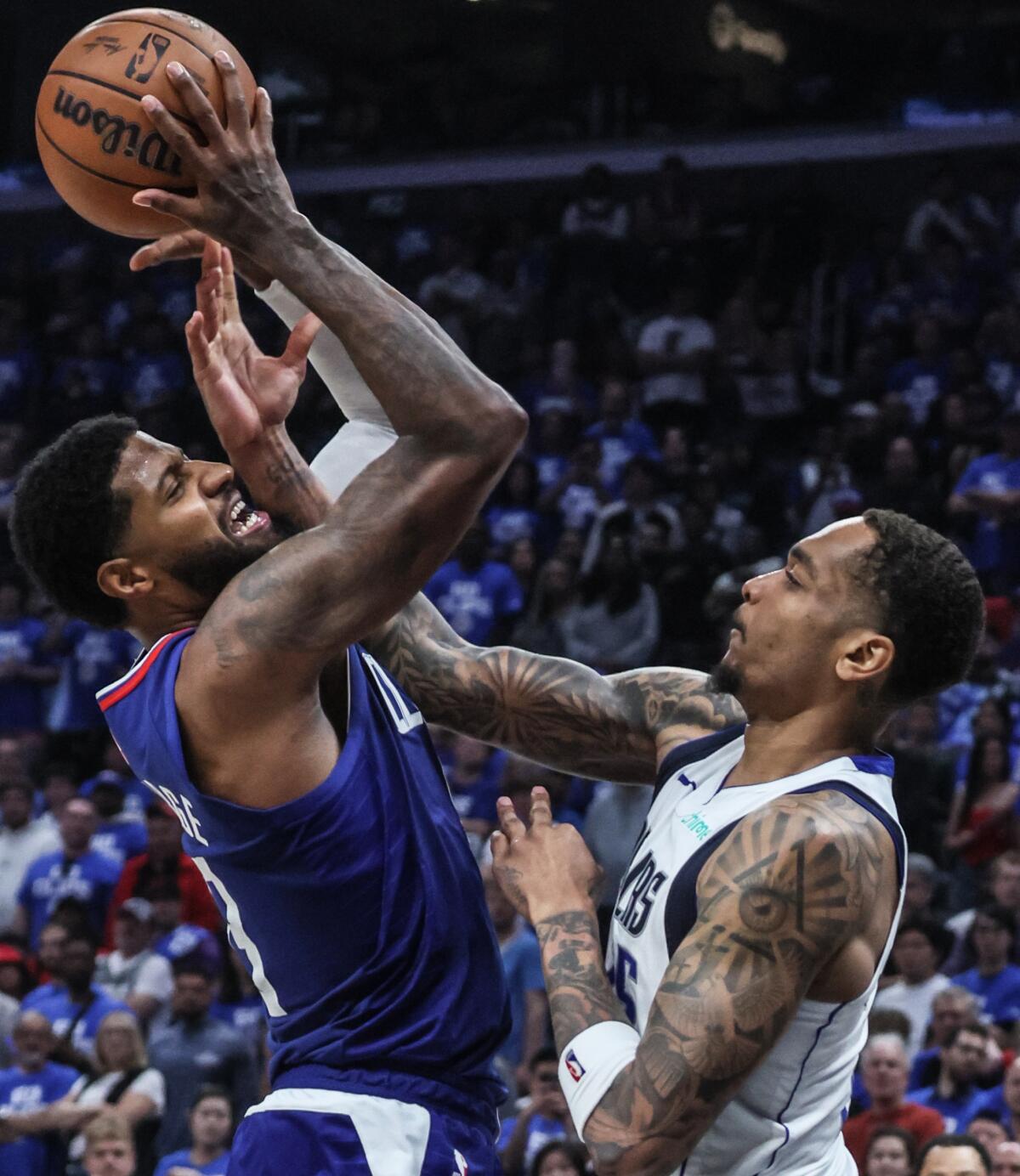 Clippers'ın forveti Paul George (solda), Mavericks'in forveti PJ Washington üzerinden şutunu çekiyor.
