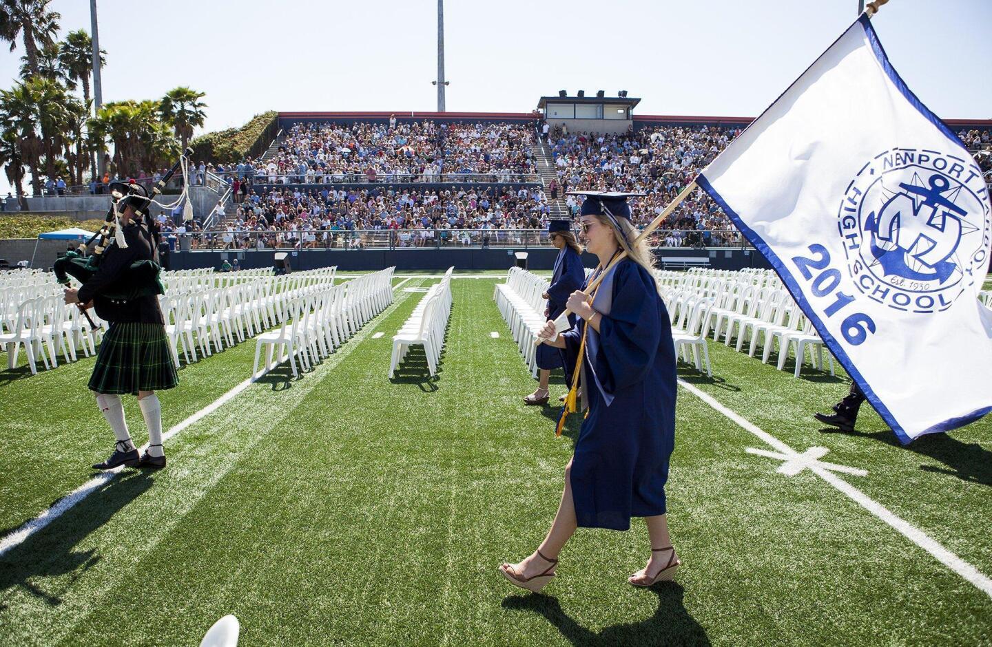 Peyton Espley-Jones, the ASB president, carries a Newport Harbor High School banner during the processional at the 2016 commencement ceremony at Orange Coast College on Thursday.