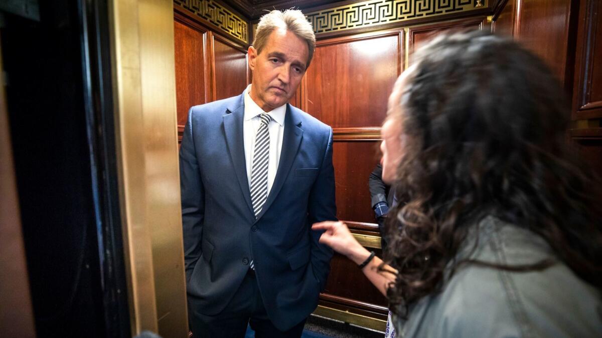 A woman who said she is a survivor of a sexual assault confronts Senator Arizona Jeff Flake (R-AZ) in an elevator after Flake announced that he would vote to confirm Supreme Court nominee Brett Kavanaugh in the Russell Senate Office Building in Washington on Sept. 28.
