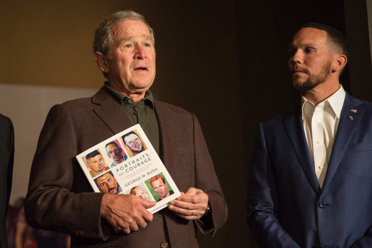 Former President George W. Bush with Johnnie Yellock, a veteran featured in Bush's new book "Portraits of Courage," at his presidential library in Dallas on Feb. 28.