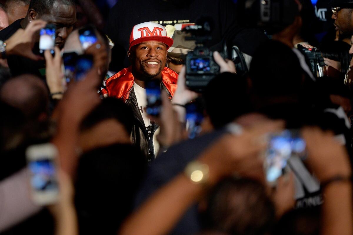 Floyd Mayweather Jr. smiles as he makes his way toward the ring before his welterweight unification title bout against Marcos Maidana at the MGM Garden Arena in Las Vegas.