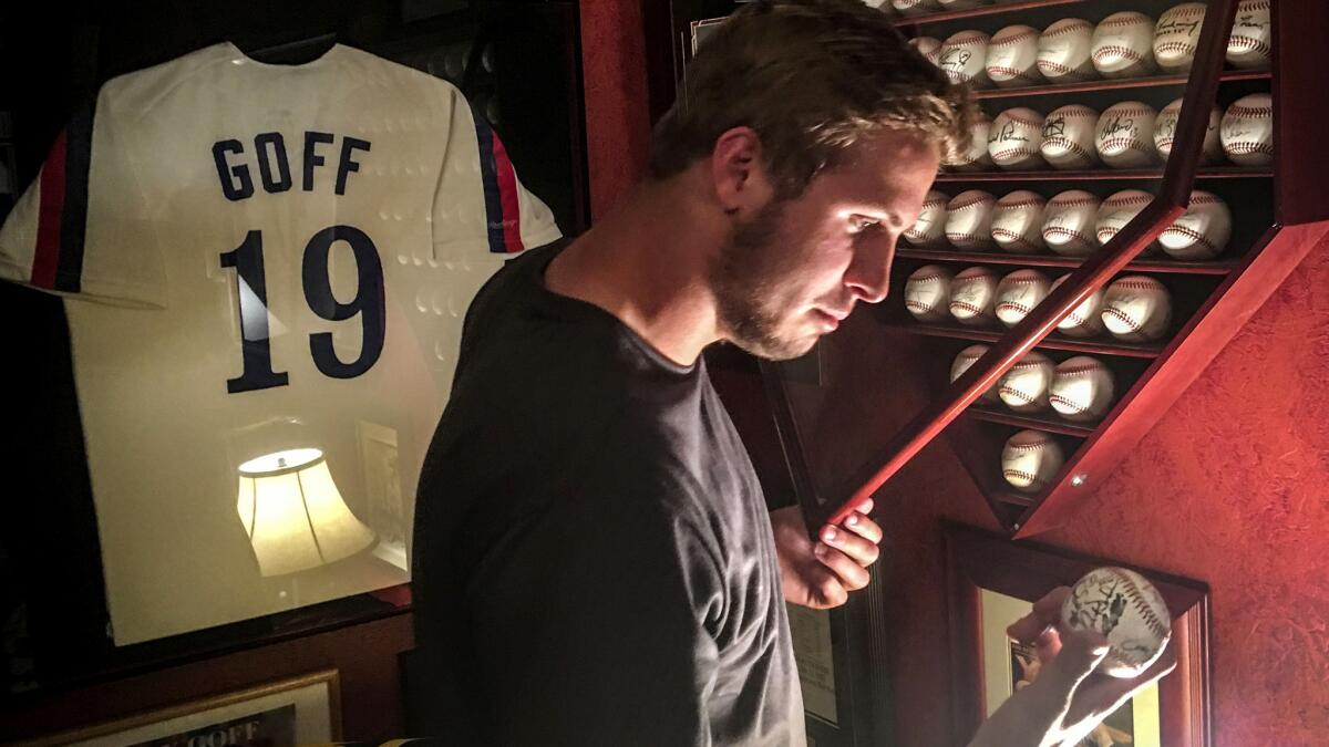 New Rams quarterback Jared Goff examines one of his father's mementos in the family's home in Novato, Calif., earlier this month.