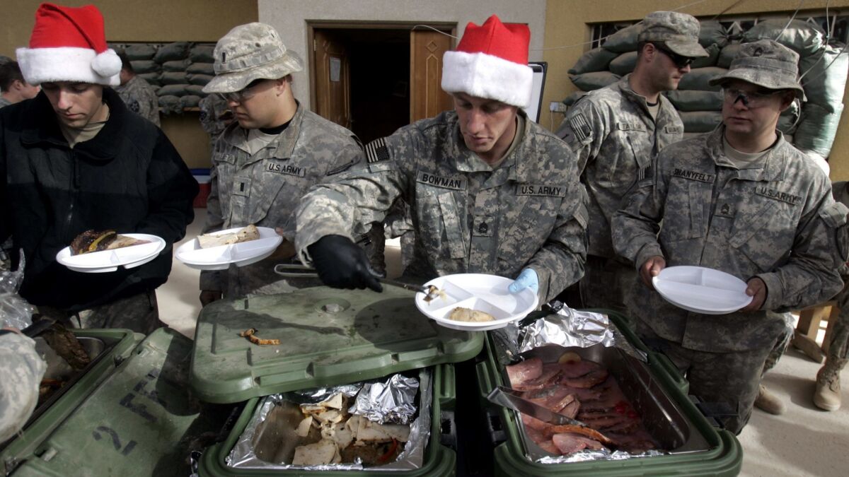 U.S. Army soldiers queue for their Christmas lunch at Kwal combat outpost in the village of Shakarat, Iraq on Dec. 25, 2007.