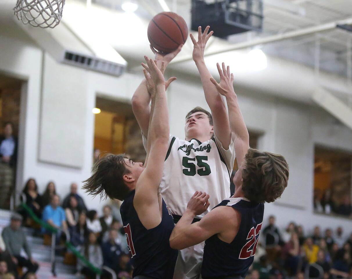 Sage Hill School's Johnny King drives to the hoop for a score between two St. Margaret's defenders in the Academy League boys' basketball championship game at home Thursday.
