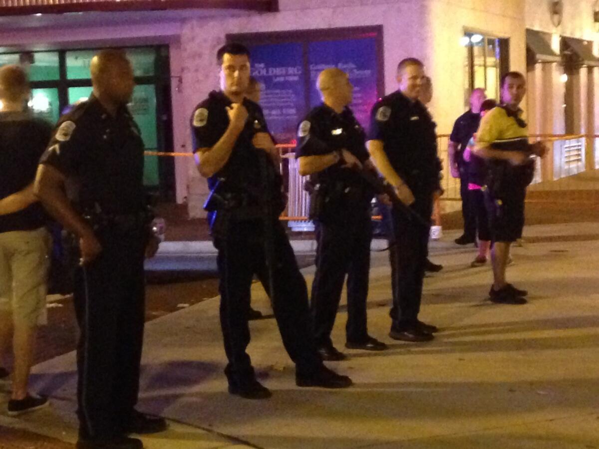 Police stand near the site of a shooting at ZombiCon that police say killed at least one person and injured four others in Fort Myers, Fla.